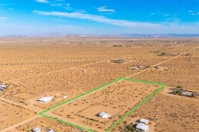 drone / aerial view featuring a mountain view, a rural view, and a desert view