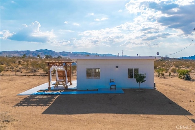 back of property featuring a patio, a mountain view, and a pergola