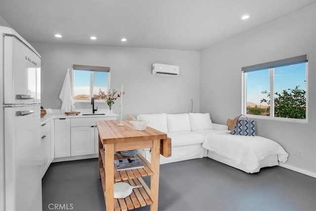 living room with a healthy amount of sunlight, an AC wall unit, recessed lighting, and concrete flooring