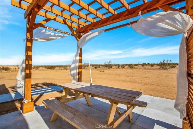 view of patio with a pergola and a rural view