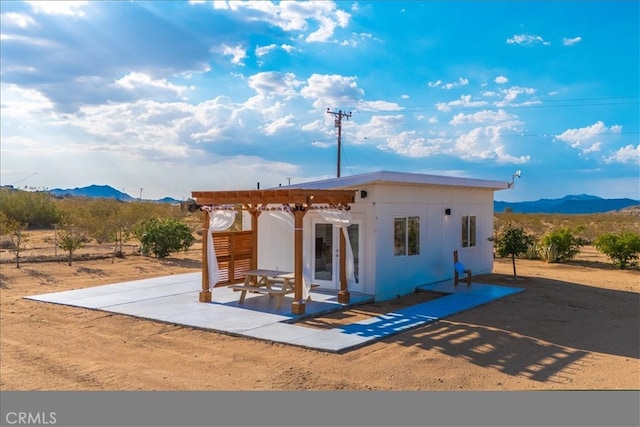 back of property with a patio, a mountain view, and a pergola