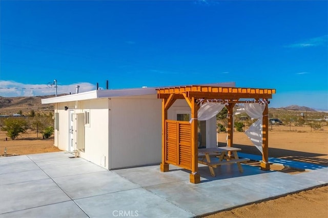 exterior space with a patio, a pergola, and a mountain view