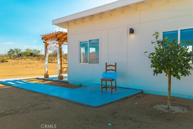 view of side of property featuring a pergola and a patio