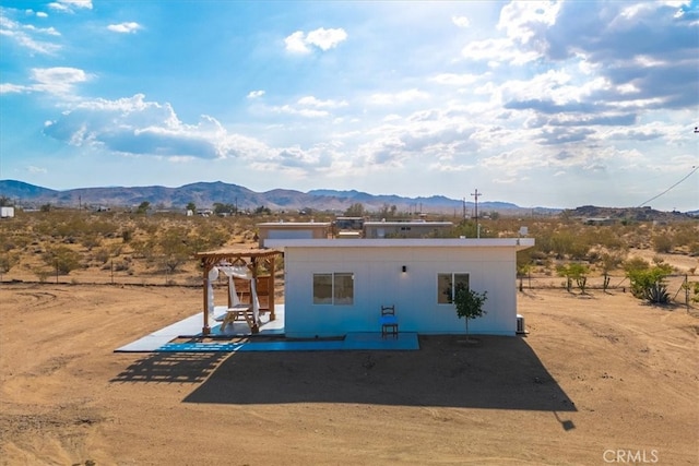 view of front of property with a patio and a mountain view