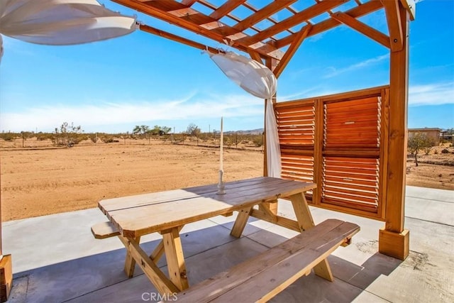 view of patio / terrace featuring a rural view, outdoor dining space, and a pergola