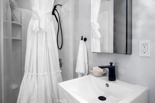 full bath featuring a shower with shower curtain and a sink
