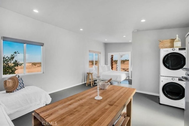 laundry area with stacked washer / dryer, recessed lighting, laundry area, and plenty of natural light