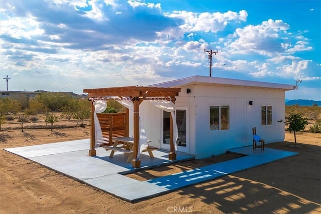 rear view of property with a pergola and a patio area