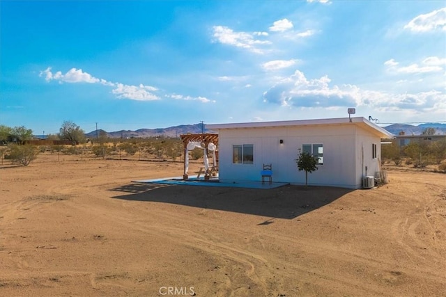 exterior space featuring a pergola, central air condition unit, and a mountain view