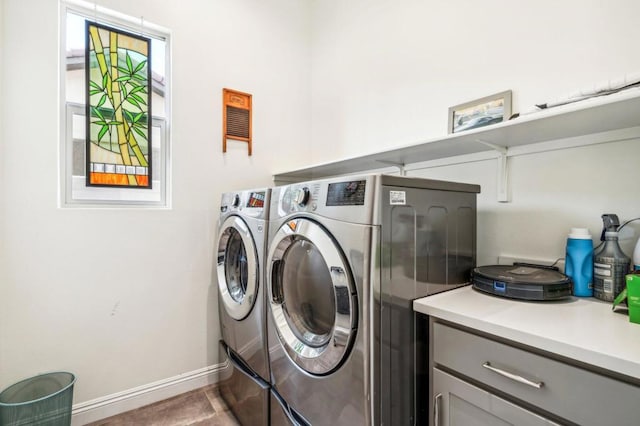 clothes washing area with dark tile patterned floors and washer and dryer