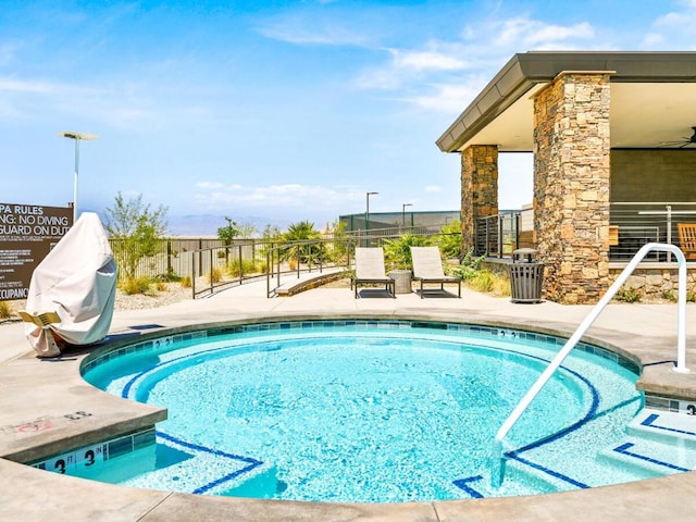 view of swimming pool with a hot tub and a patio