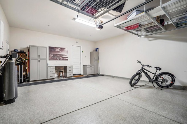 garage with a garage door opener and white fridge