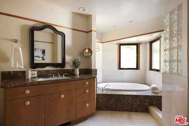 bathroom with vanity, tile patterned floors, and a relaxing tiled tub