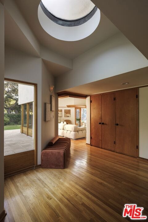 unfurnished living room featuring light wood-type flooring and a tray ceiling