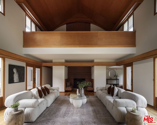 living room featuring hardwood / wood-style flooring, a fireplace, and high vaulted ceiling