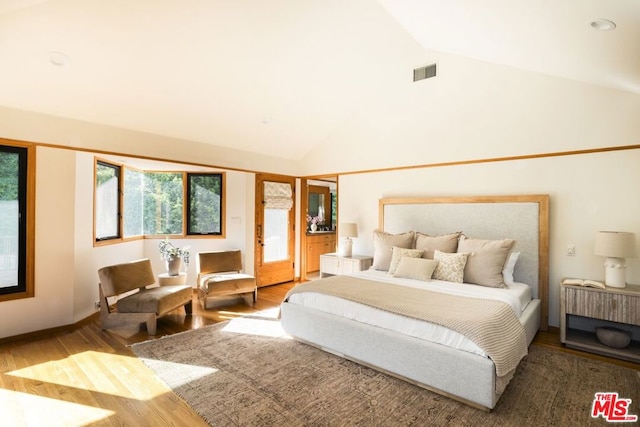 bedroom with hardwood / wood-style flooring and high vaulted ceiling