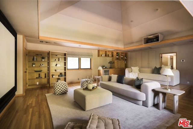 living room with a tray ceiling and dark hardwood / wood-style floors