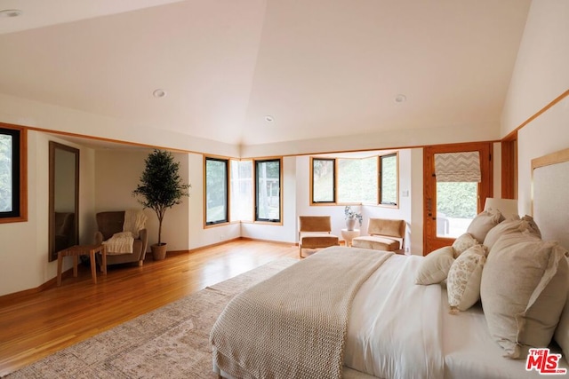 bedroom featuring high vaulted ceiling and light wood-type flooring