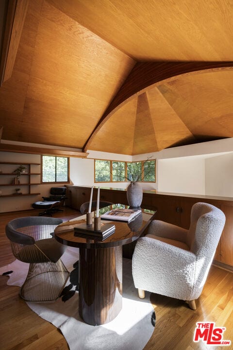 living area featuring wood-type flooring, lofted ceiling, wood walls, and wooden ceiling