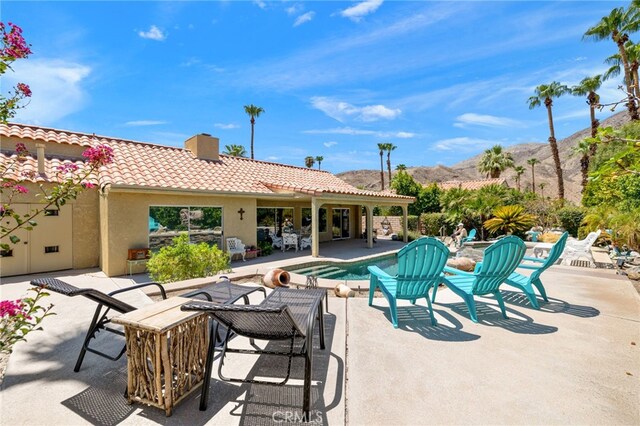 view of pool with a mountain view and a patio area