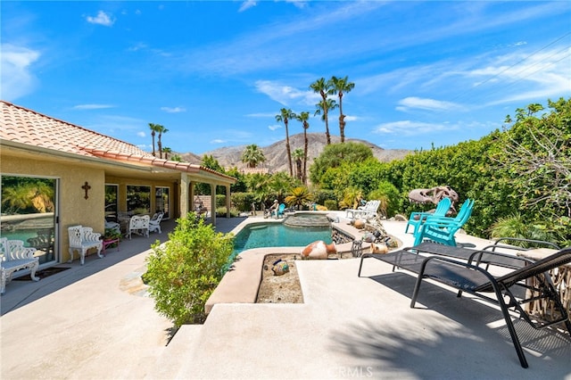 view of swimming pool with a mountain view, an in ground hot tub, and a patio area