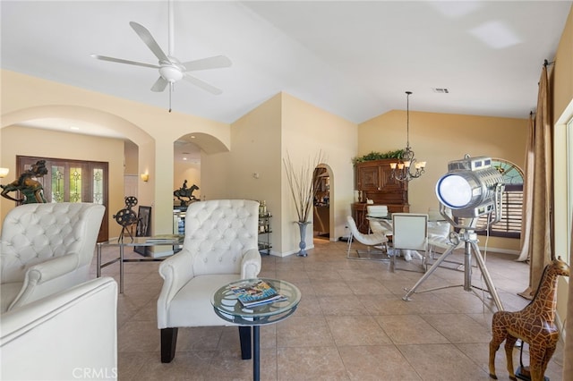 tiled living room with ceiling fan with notable chandelier and lofted ceiling