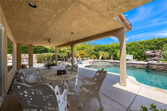 view of patio / terrace with a pool with hot tub