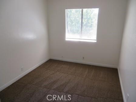 spare room featuring dark carpet