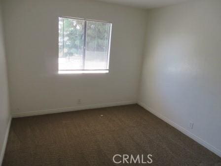 empty room featuring dark carpet