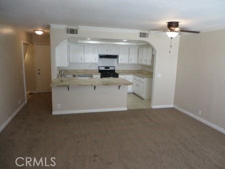 kitchen with a kitchen breakfast bar, white cabinetry, kitchen peninsula, and black electric range