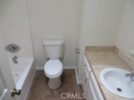 bathroom featuring a washtub, tile patterned floors, vanity, and toilet