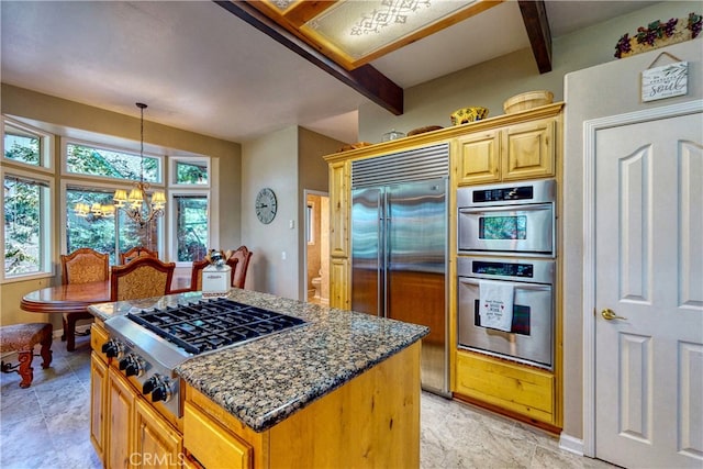 kitchen with beam ceiling, a healthy amount of sunlight, dark stone counters, and stainless steel appliances