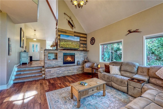 living room featuring a chandelier, a fireplace, wood-type flooring, and high vaulted ceiling