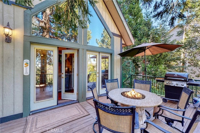 wooden terrace with a grill and a fire pit