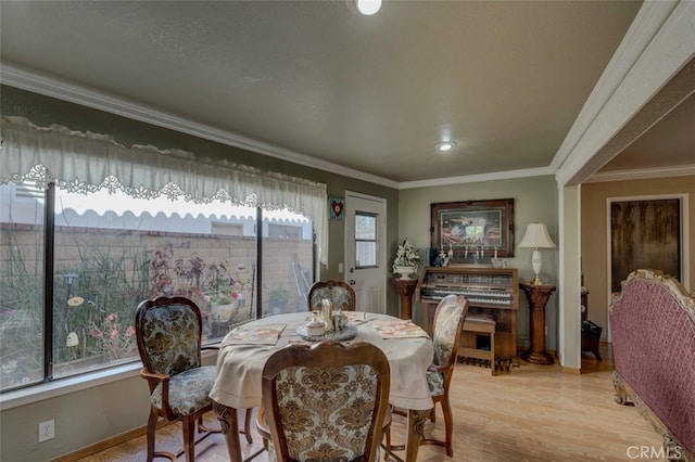 dining area with light hardwood / wood-style flooring, plenty of natural light, and ornamental molding