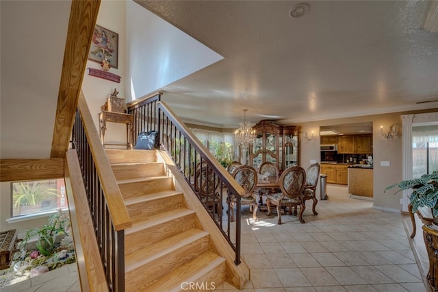 staircase featuring a notable chandelier, tile patterned floors, and a wealth of natural light