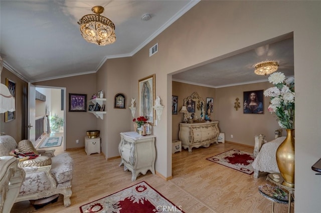 living room with light wood-type flooring, a chandelier, and crown molding