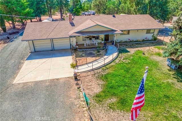 ranch-style house featuring covered porch, a garage, and a front yard