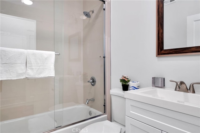 full bathroom with vanity, combined bath / shower with glass door, and toilet