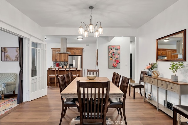 dining area featuring an inviting chandelier and light wood-type flooring