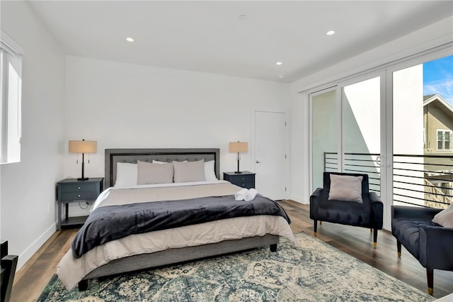 bedroom with multiple windows and dark hardwood / wood-style flooring