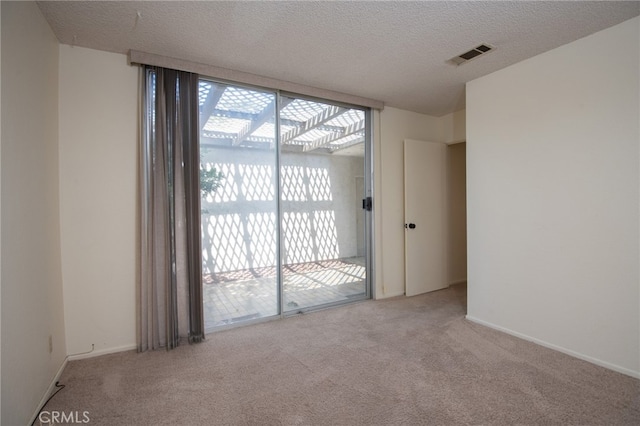 carpeted empty room with a textured ceiling