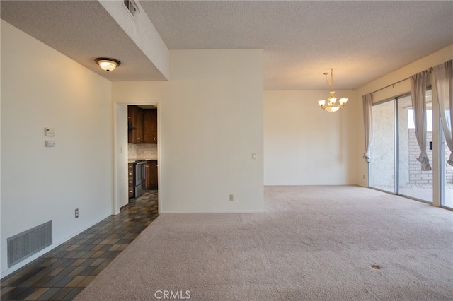 unfurnished room with dark carpet, a notable chandelier, and a textured ceiling