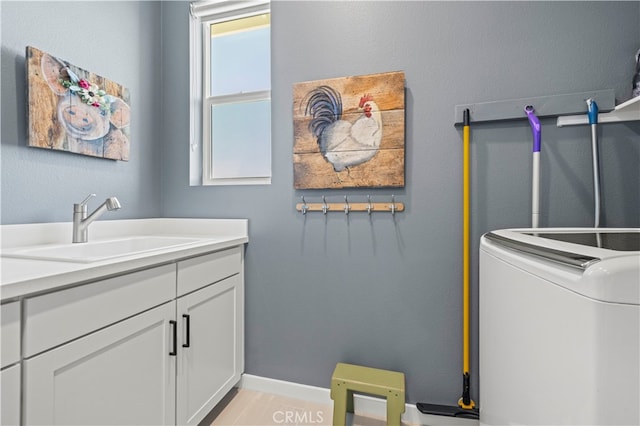 laundry area with sink, washer / dryer, and cabinets