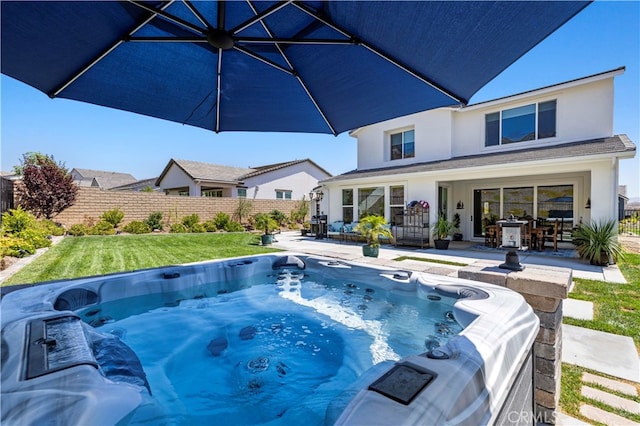 view of swimming pool featuring a patio, a yard, and a hot tub