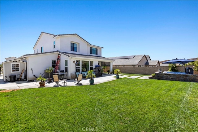 back of property with a yard and a patio area