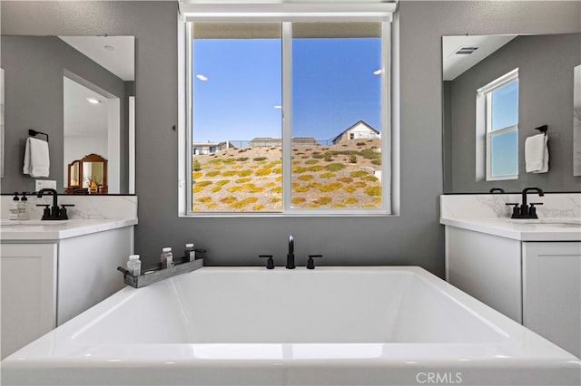 bathroom with a tub to relax in and vanity