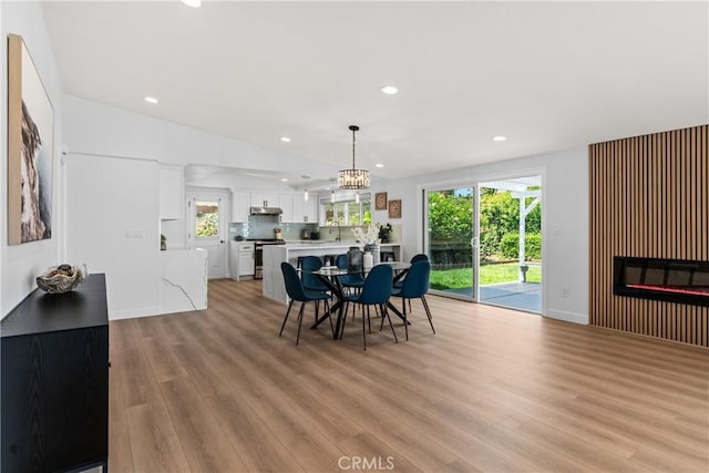 dining room with light hardwood / wood-style floors and an inviting chandelier