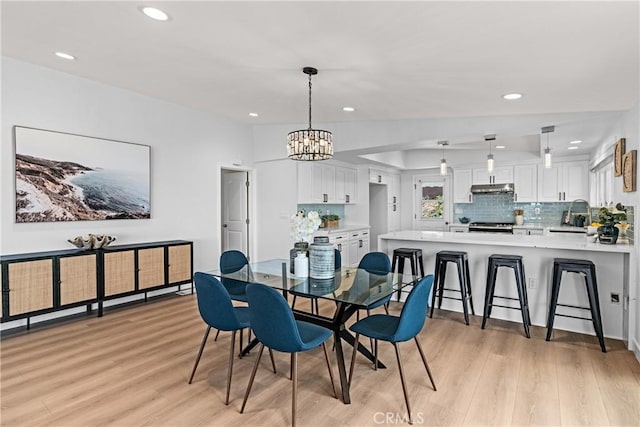 dining room featuring light wood-type flooring and an inviting chandelier