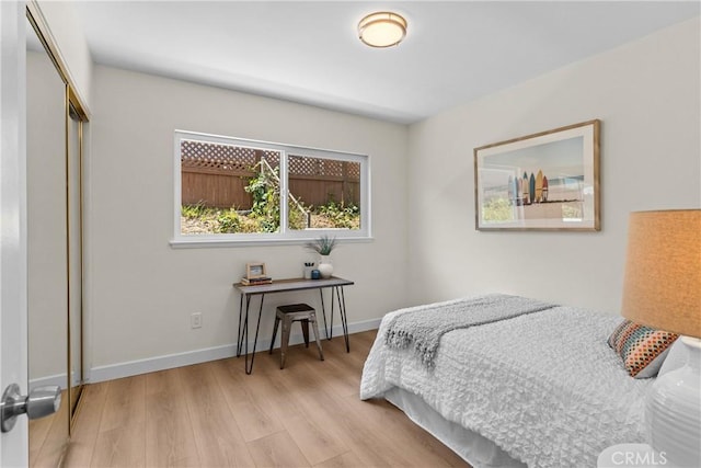 bedroom with light hardwood / wood-style floors and a closet